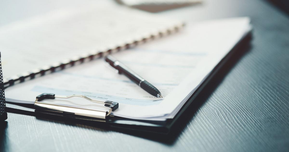 Clipboard with papers and pen