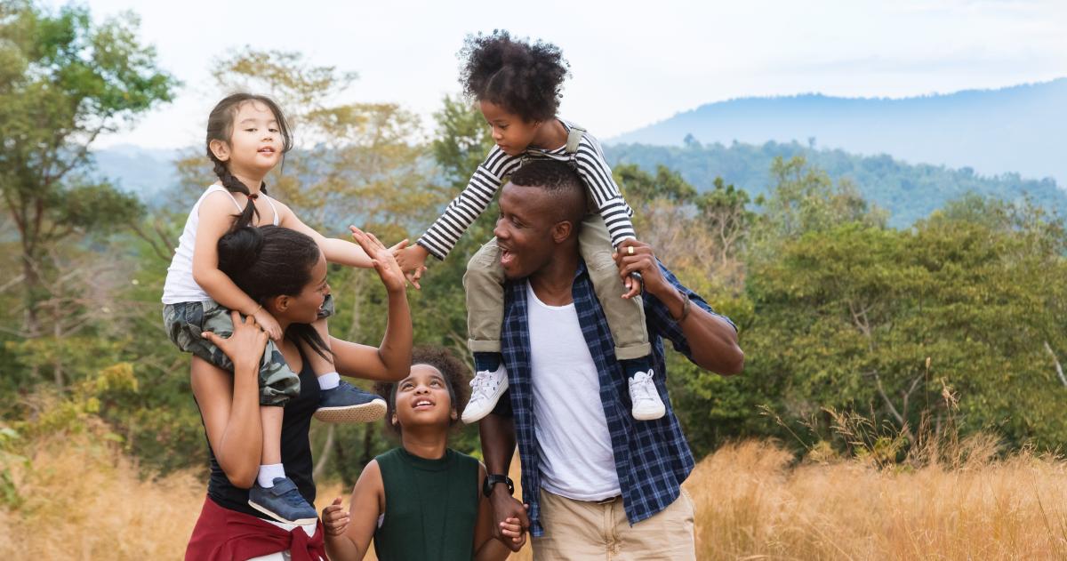 Parents with three kids on a hike with nature in the background