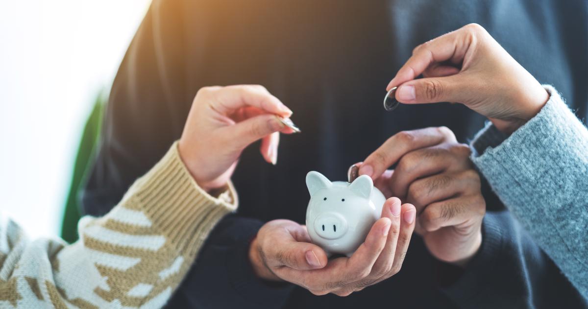 Piggy bank with three hands putting coins in