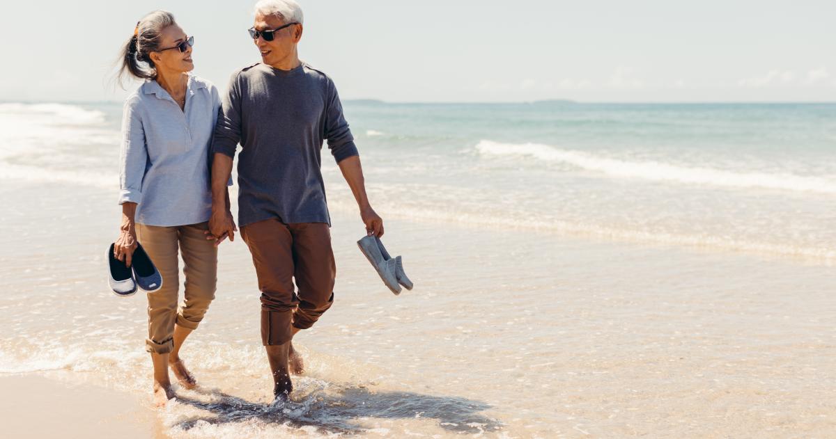 Retired couple walking on beach