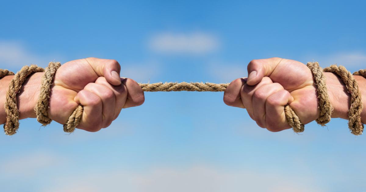 Two hands pulling a rope in opposite directions