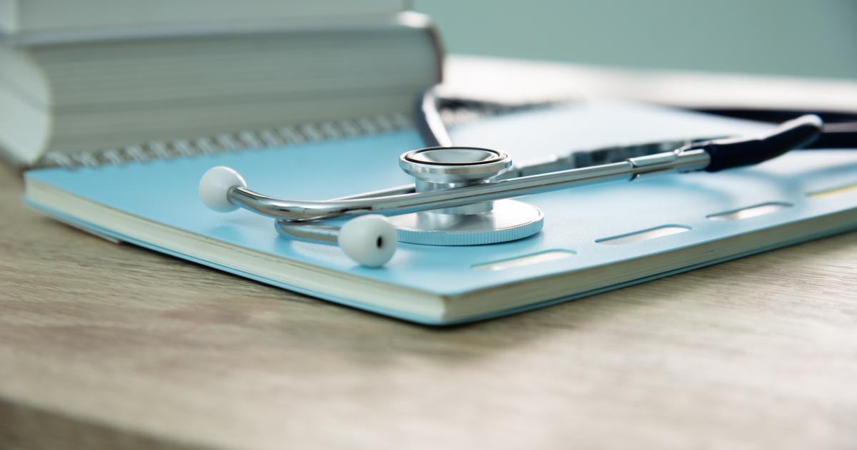 Desk with a notebook and stethoscope on it