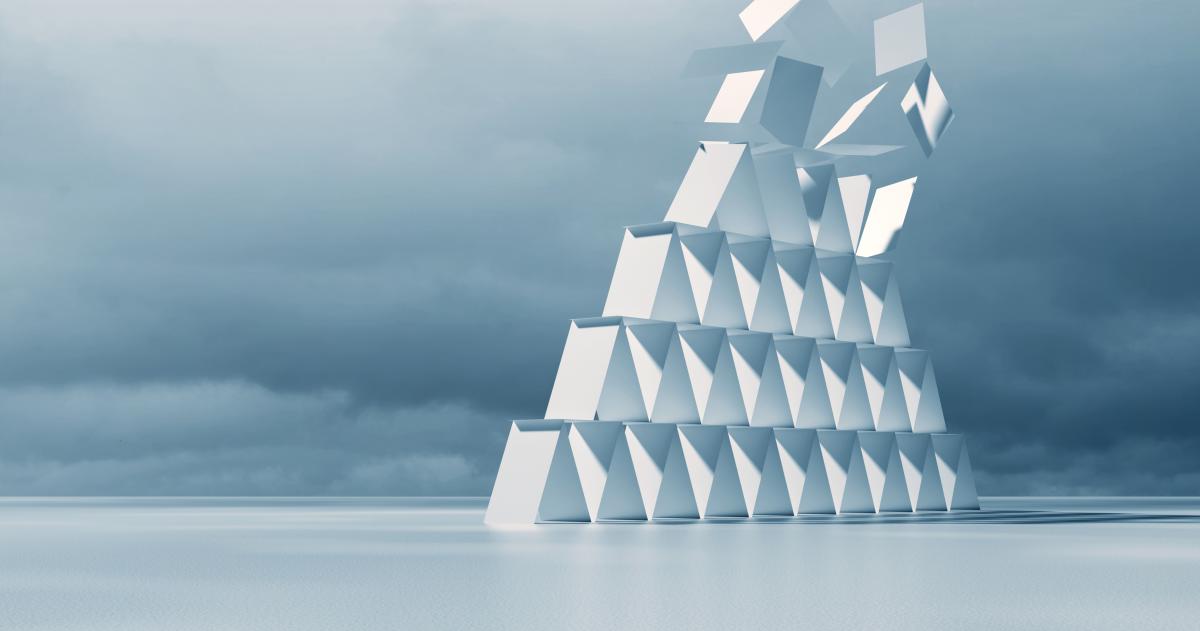 Pyramid of cards with the top rows falling off 