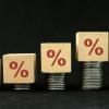 Image of wooden blocks with a percent type stacked on coins that increase