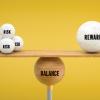 Image with a yellow background with a multiple round objects listed as risk on one side and one round object on the other labeled reward