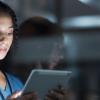 A female physician holding and looking at a tablet 