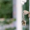 Image of a silver key in a lock with a house on the key chain