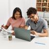 Young couple with a laptop, calculator, and papers at a counter