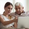 Woman helping an older man on a computer