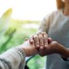 Person holding another person's hand comfortingly