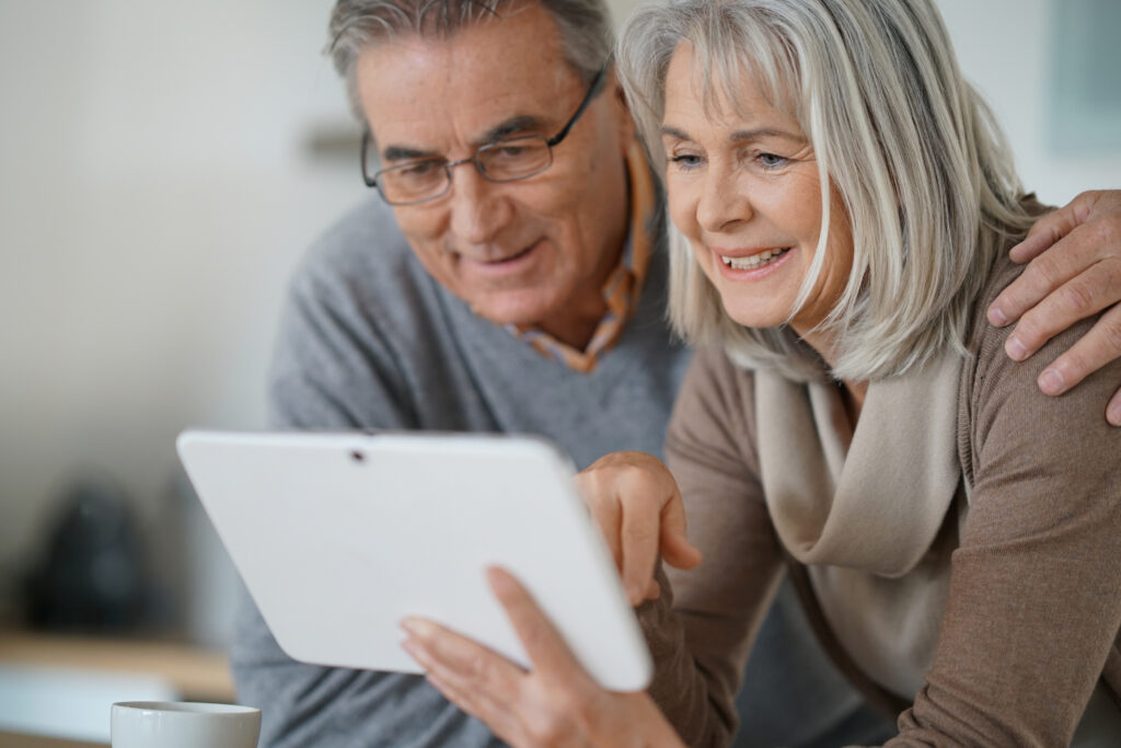 Senior couple at home using digital tablet