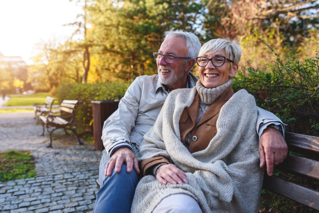 A couple smiling on a park bench